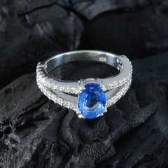 Teresa blue halo gemstone ring with oval blue center stone and diamond accents on silver band