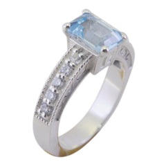 Isabella blue halo gemstone ring with rectangular blue center stone and small diamonds on silver band