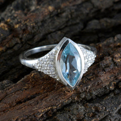 Cecilia blue halo ring for women with marquise cut blue gemstone and silver band on wood
