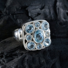 Josephine silver blue navratna ring with central oval blue gemstone and eight round aquamarine stones in square cluster