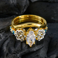 Ella gold ring featuring intricate silver knots and blue penta gemstone ring accents