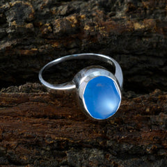 Xiu elegant blue solitaire ring with a polished silver band on natural wood background