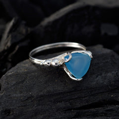 Clara blue solitaire ring with a triangular blue gemstone set in a silver band on dark textured background
