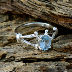 Bella silver blue solitaire ring for women with oval gemstone on rustic wooden background