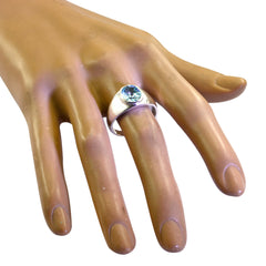Aria blue solitaire ring for women with a round blue gemstone on a silver band worn on a display hand