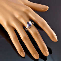 Camila blue solitaire ring with marquise cut blue gemstone on silver band worn on hand