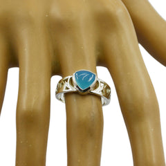 Maya blue solitaire ring with a triangular blue stone set in a silver decorative band on a mannequin hand
