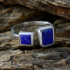 Camilla blue toi et moi ring with two square blue stones set in silver band on rustic wood
