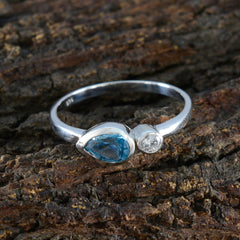 Nora sterling silver band with pear blue gemstone and round diamond blue toi et moi ring photographed on wood