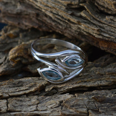 Micaela blue toi et moi ring with two marquise blue gemstones set in silver band on textured wood