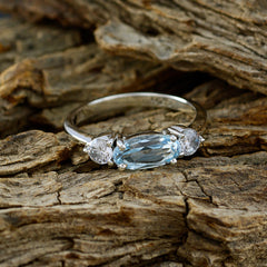 Emi blue trilogy gemstone ring with oval blue center stone and two clear side stones on silver band