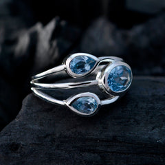 Katharina boho blue gemstone ring with three blue stones set in silver band on dark background