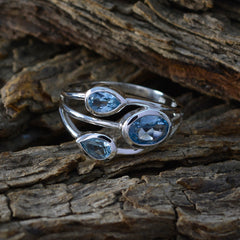 Katharina boho blue gemstone ring with three blue stones set in silver on rustic wood background