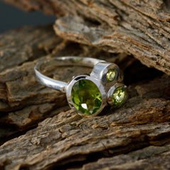 Victoria boho green gemstone ring with three faceted green stones set in silver band on rustic wood