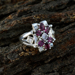 Angel boho multicolor gemstone ring featuring red and clear stones in silver setting on wooden background