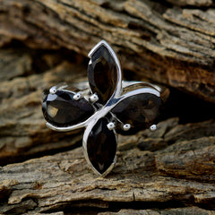 Savannah brown gemstone floral ring with four marquise-cut stones set in silver on rustic wood