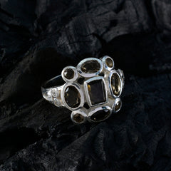 Hanna brown navratna ring with multiple brown gemstones set in silver band on dark textured background