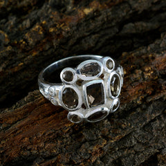 Hanna brown navratna ring with multiple brown gemstones set in silver band on rustic wood