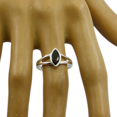 Naomi brown solitaire ring with marquise-cut stone on a silver band displayed on a hand model