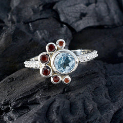 Ling silver ring with central blue gemstone and red accent stones on pave band colorful party wear fashion ring
