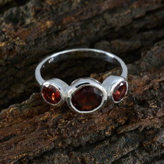 Yuki contemporary red gemstone ring with three deep red stones set in silver band on wood background