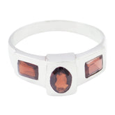 Emilia cultural red trilogy ring with oval center stone and two rectangular red gemstones in polished silver band