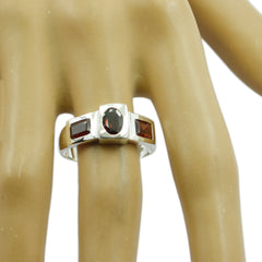 Emilia cultural red trilogy ring silver band with oval center and two rectangular side stones on hand