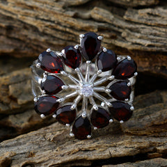 Nisa floral red gemstone ring featuring deep red teardrop gemstones arranged in a flower design with a silver band