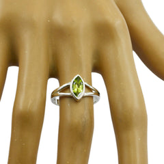 Mei geometric green solitaire ring with marquise-cut stone on display hand model
