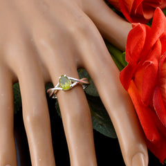 Li Lee green gemstone solitaire ring with pear-shaped stone on hand with red flowers