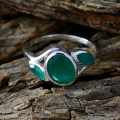 Priya green gemstone statement ring with three oval green stones set in silver band on wood