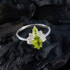 Ha-eun green gemstone toi et moi ring with two bright green stones and silver band on black textured surface