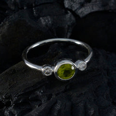 Lakshmi green gemstone trilogy ring with round green center stone and two small diamond accents on sterling silver band