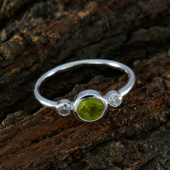 Lakshmi sterling silver green gemstone trilogy ring featuring a central peridot and two diamond accents