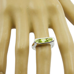 Valentina green gemstone trilogy ring with three green stones set in a silver band on a hand