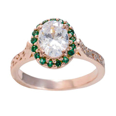 Putri green halo gemstone ring with a large clear center stone surrounded by small green gemstones on a rose gold band