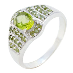 Isadora green halo ring for women featuring a round peridot center and pave green stones on sterling silver band