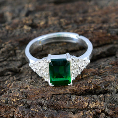 Sarah green halo ring for women with rectangular green gemstone and silver band on wood background
