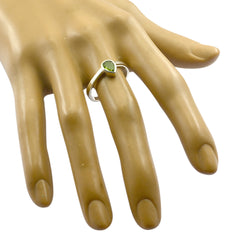 Olivia green solitaire ring with a pear-shaped green gemstone on a silver band worn on a mannequin hand