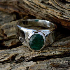 Antonia silver green solitaire ring with oval emerald gemstone on rustic wood background