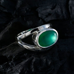 Emma heritage green gemstone ring in silver setting with oval green stone on dark textured background