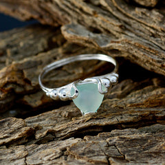 Eliza aqua solitaire gemstone ring with a delicate silver band resting on textured wood