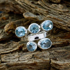 Mila sterling silver ring with five light blue gemstones in a clustered modern design on wood background blue gemstone penta ring