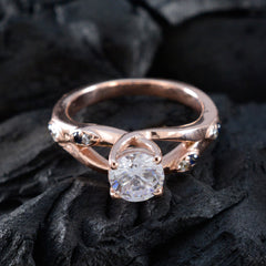 Isabel ring with a large blue gemstone statement ring design and small accent stones on a rose gold band