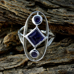 Siti blue gemstone trilogy ring with silver setting on rustic wooden background