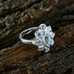 Lucy elegant silver blue navratna ring with multiple blue gemstones on textured wood background