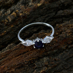 Ava blue trilogy gemstone ring with a deep blue center stone flanked by two clear gemstones on silver band