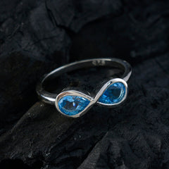 Siti boho blue gemstone ring with infinity design and silver band on dark textured background