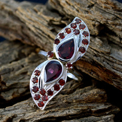 Natcha contemporary red gemstone ring with twin pear shaped garnet centers and halo of round stones on silver band