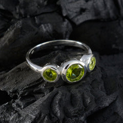 Lily silver green gemstone trilogy ring with three bezel set peridot stones on dark textured stone